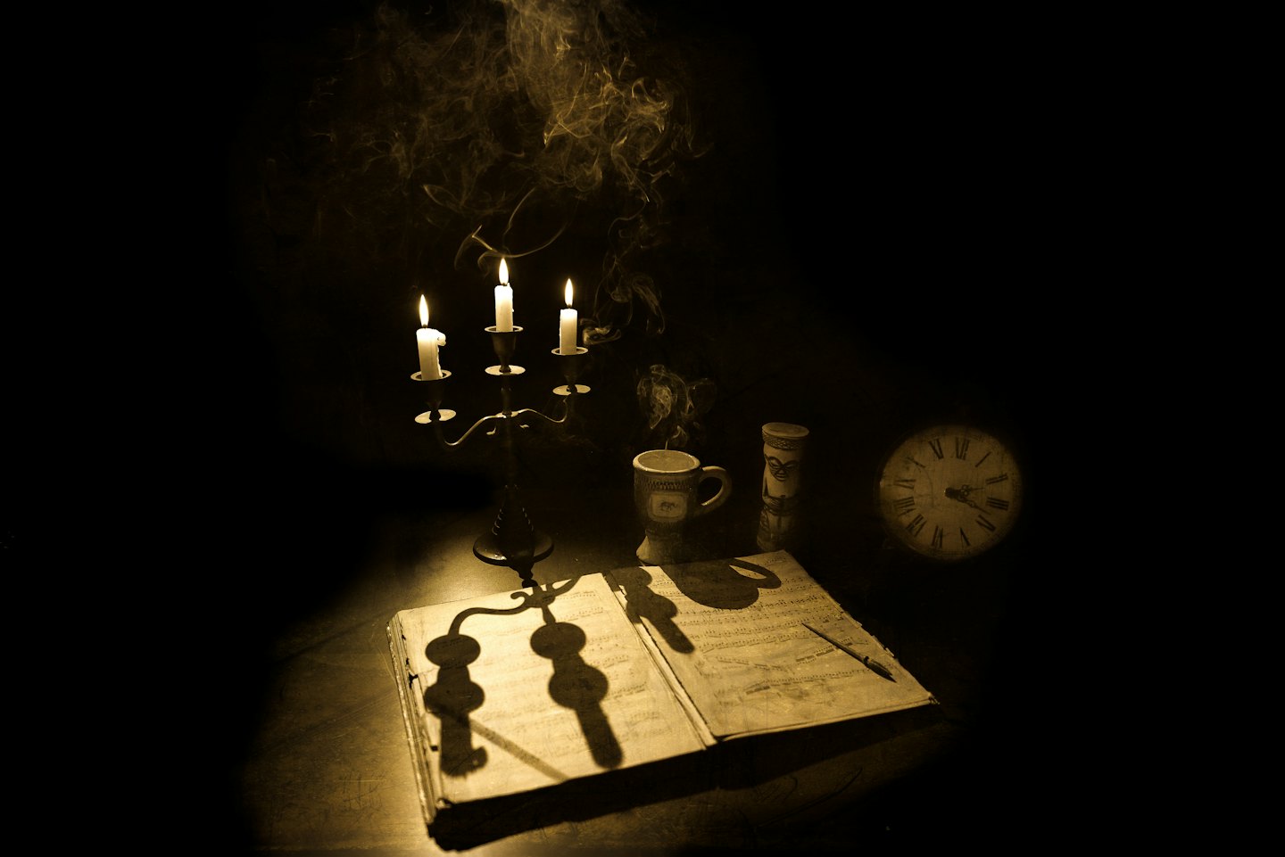 Un candelabro e un libro di musica illuminati da una calda luce di candela.