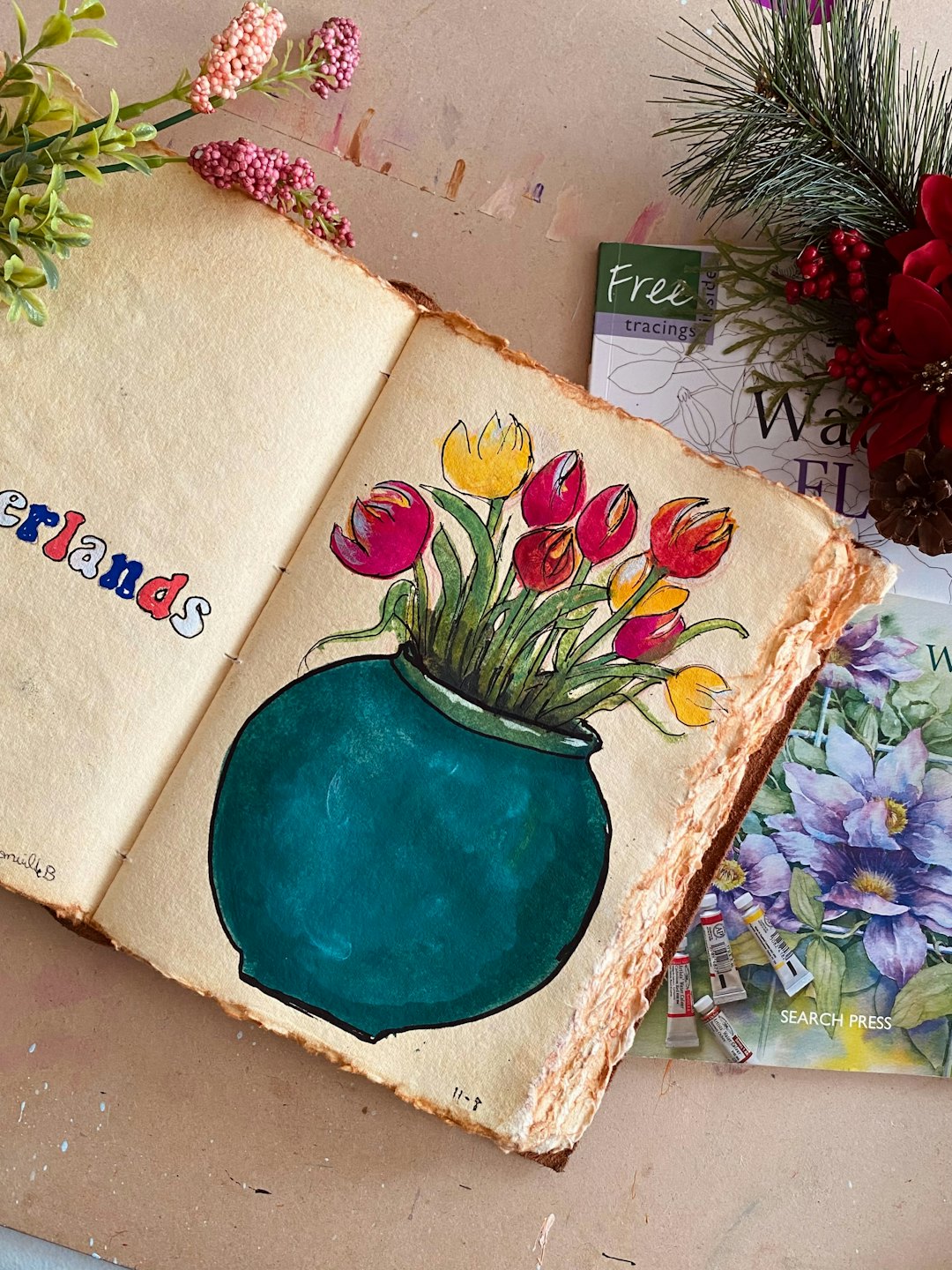 Un diario d'arte aperto con tulipani ad acquerello riposa su una scrivania.